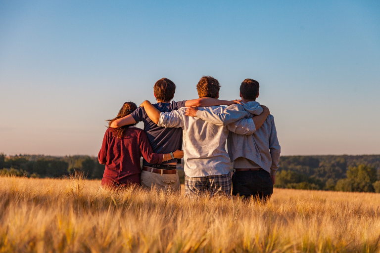 people hugging in field