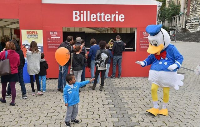 Little boy pointing at someone in a duck costume.