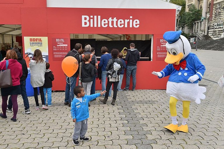 Little boy pointing at someone in a duck costume.