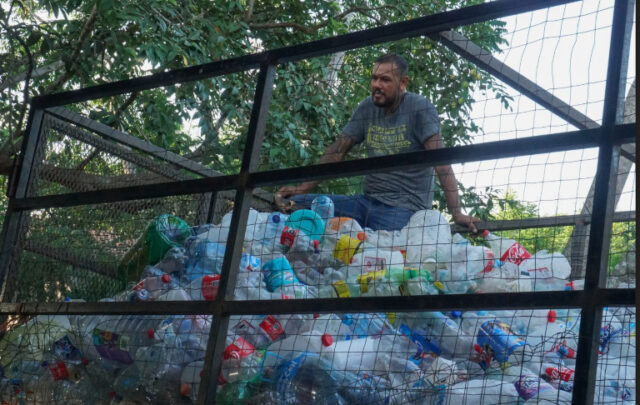 Eleno collects plastic trash for recycling.