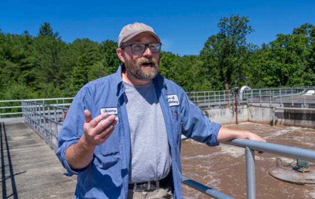 Jeremy Rathbun stands in front of one of the 400,000 gallon Sequencing Batch Reactor basins at the wastewater treatment facility in Middlebury, Vermont. These biological reactors process approximately 1,000,000 gallons per day. (Terry Allen, Barn Raiser)