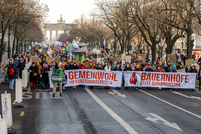 Wir haben es satt! demonstrators make their way up Berlin’s Unter den Linden with banners that say “Common good before corporate interests” and “Farms not agri-industry”. Photo: Fabian Melber/www.wir-haben-es-satt.de