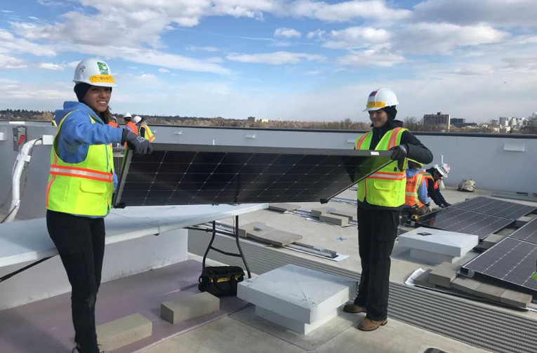 Grid Alternatives WEBuild (Women in Energy) rooftop solar installation with National Tribal Program Co-Executive Director Tanksi Clairmont.